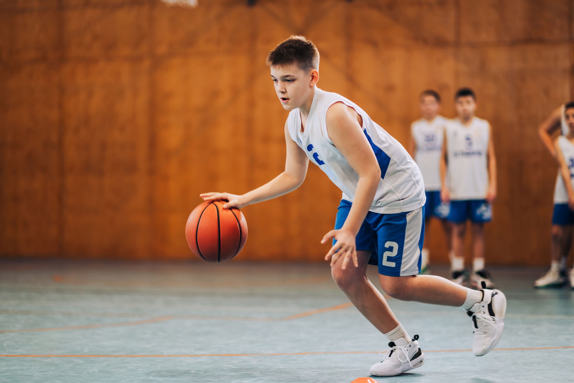 Basketball player dribbles with intent on court