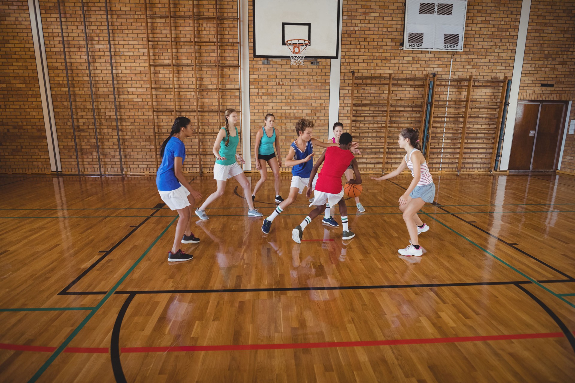 High school kids playing basketball in the court